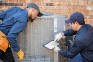 two-technicians-working-on-outside-ac-unit