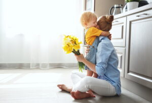 son-hugging-mom-on-kitchen-floor