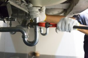 plumber-hands-working-on-pipe-under-sink