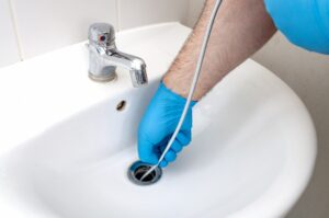 plumber-cleaning-bathroom-sink-drain
