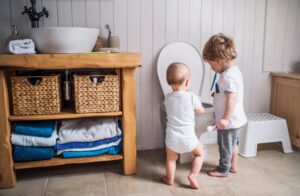 children-with-toothbrushes-near-an-open-toilet